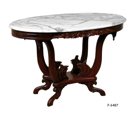 CENTER TABLE: Victorian, Mahogany, oval top with loose white marble Top, four scroll shaped supports on oblong footed base with floral carvings, 46" X 27-1/2" X 29-1/2"H